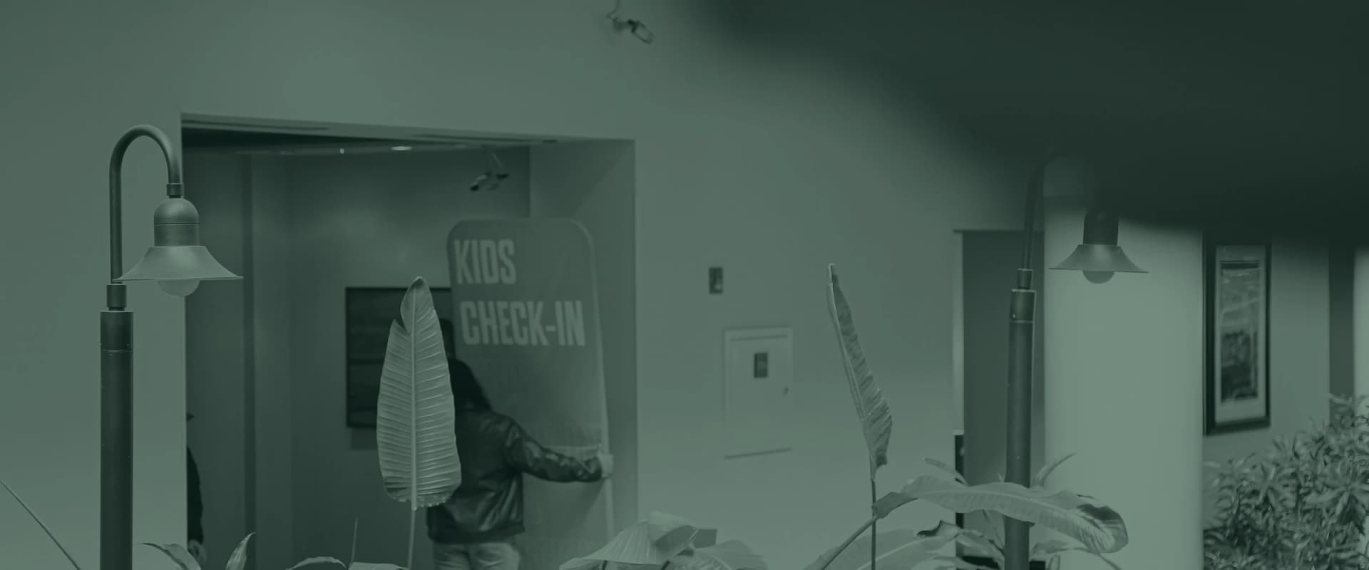 A bright red Kids Check-In sign beside the doorway