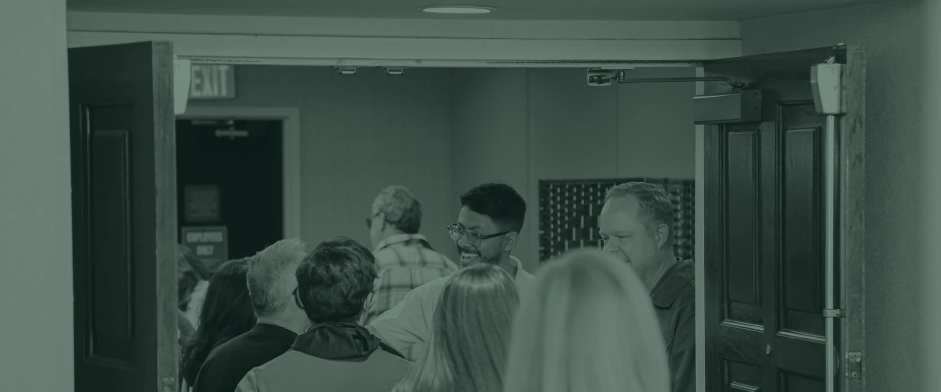 A small group of people walking in through the doors together